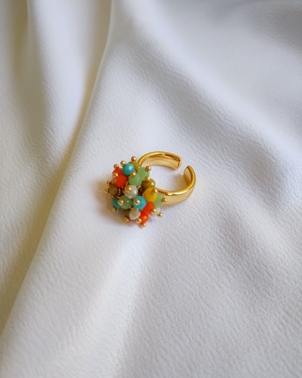 Anel dourado regulável com cacho de contas coloridas estilo boho.
