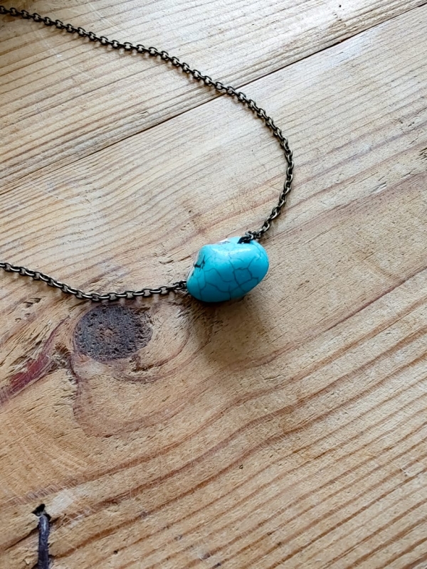 Colar boho com corrente envelhecida e pedra turquesa única no centro.