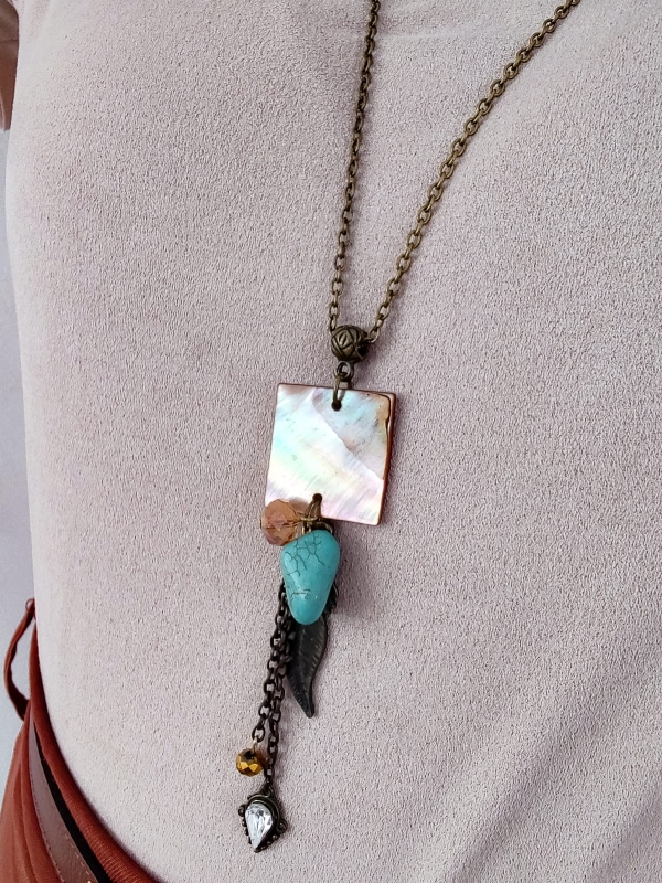 Colar artesanal boho com corrente envelhecida, pingente madrepérola quadrado, pedra turquesa e detalhes metálicos com cristais.