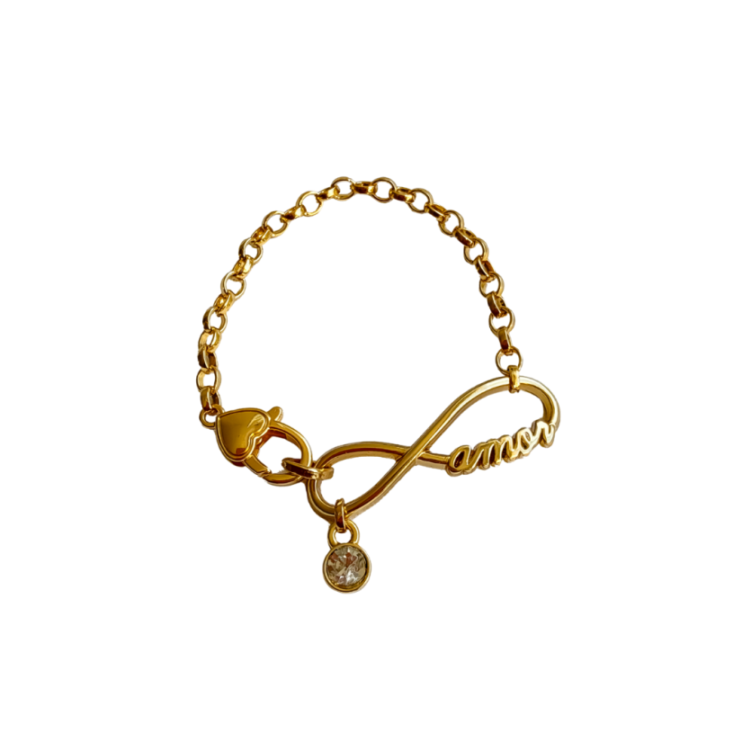 Pulseira dourada com corrente delicada e pingente no formato de infinito com a palavra “amor” e um pequeno cristal pendente.