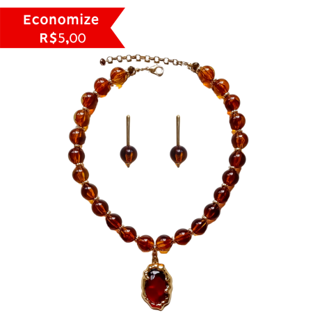 Conjunto Turmalina composto por colar de resina em tons de marrom e mel com pingente central dourado e brincos coordenados sobre fundo branco.